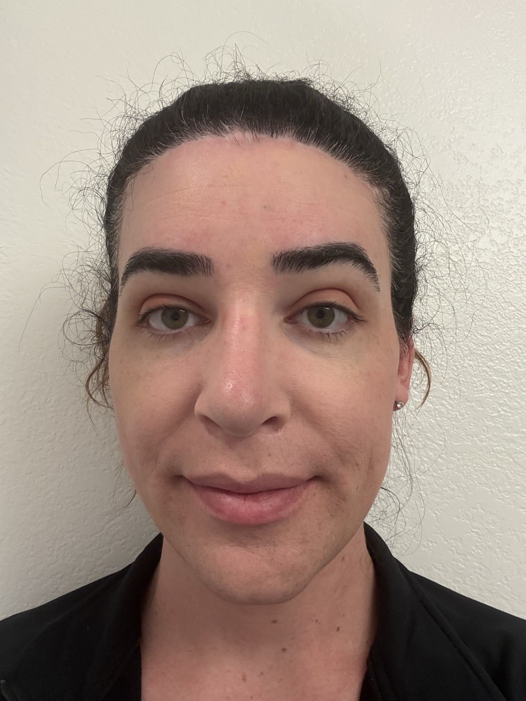 Face with all makeup applied before setting spray: eyeshadow blended across the lids, bronzer and blush defining the face, overall look finished and cohesive